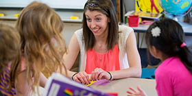 Teacher in a classroom interacting with young students