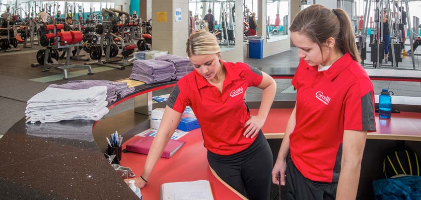 Students working at a Recreational Sports reception desk