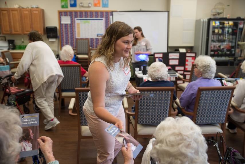 Graduate student working with community members on Aphasia Month activities