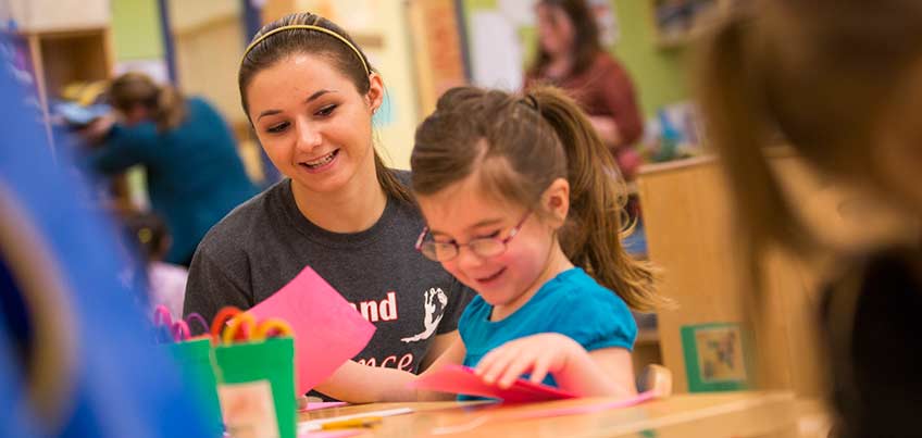 Student working with young girl