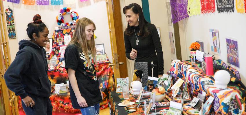 Students and professor looking at a Day of the Dead ofrenda.