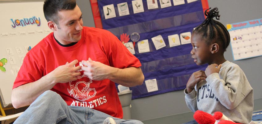 Student working with young student in the Child Care Center