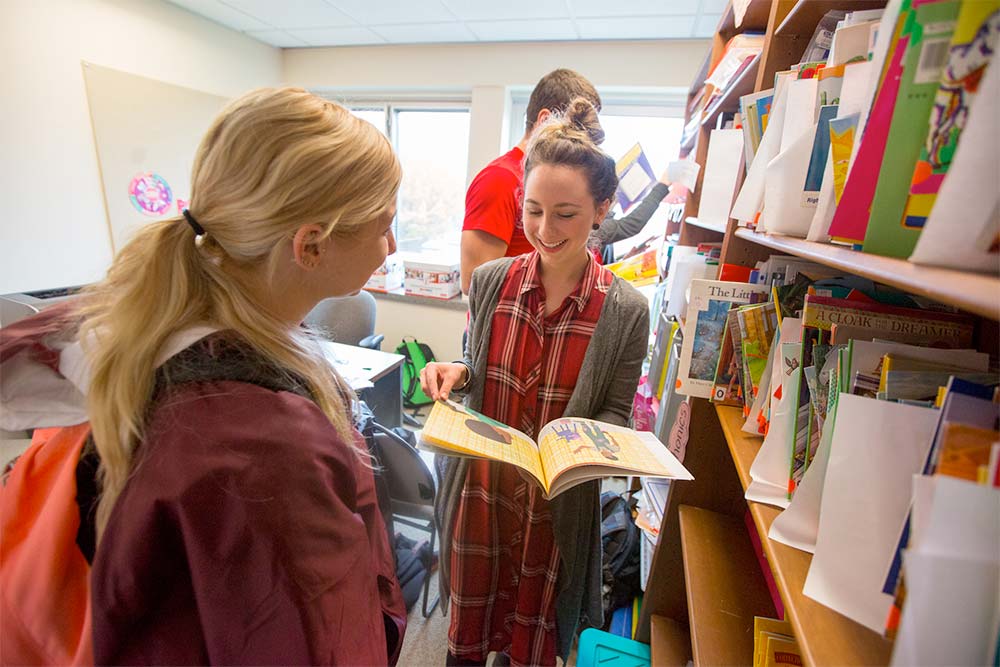 Literacy graduate students read books together