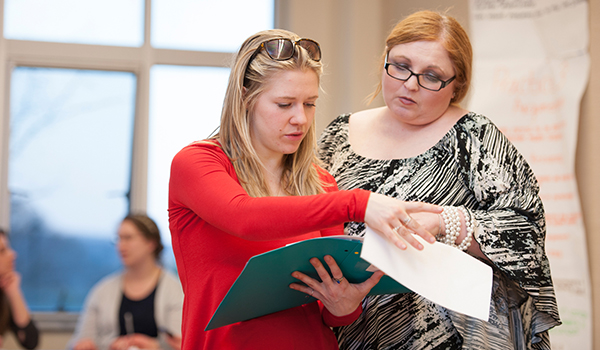 Literacy graduate student reads with professor