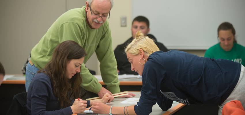 Faculty working with students on a project in class.