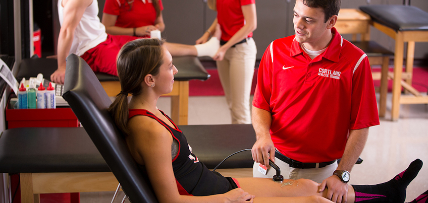 Athletic training student treats a leg injury