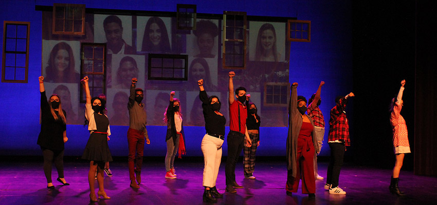 Group of students standing on stage during a musical theater production