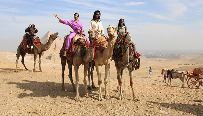 SUNY Cortland students riding camels in the desert