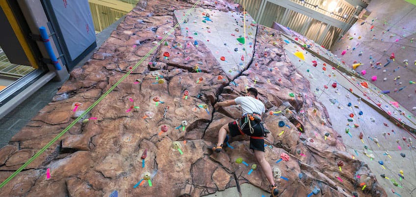 Student climbing on indoor climbing wall