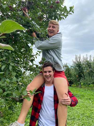 International student William Gereke picking apples