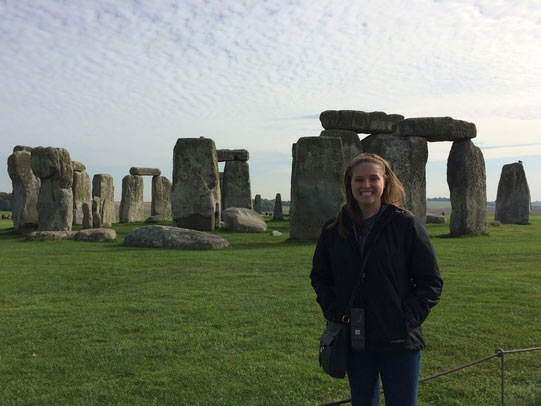 Student posing in front of Stonehenge, UK